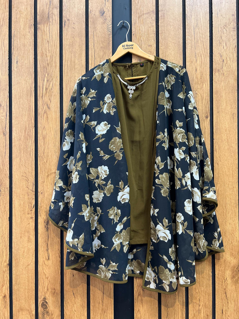 Green floral kimono-style jacket with matching inner top hanging on wooden wall.