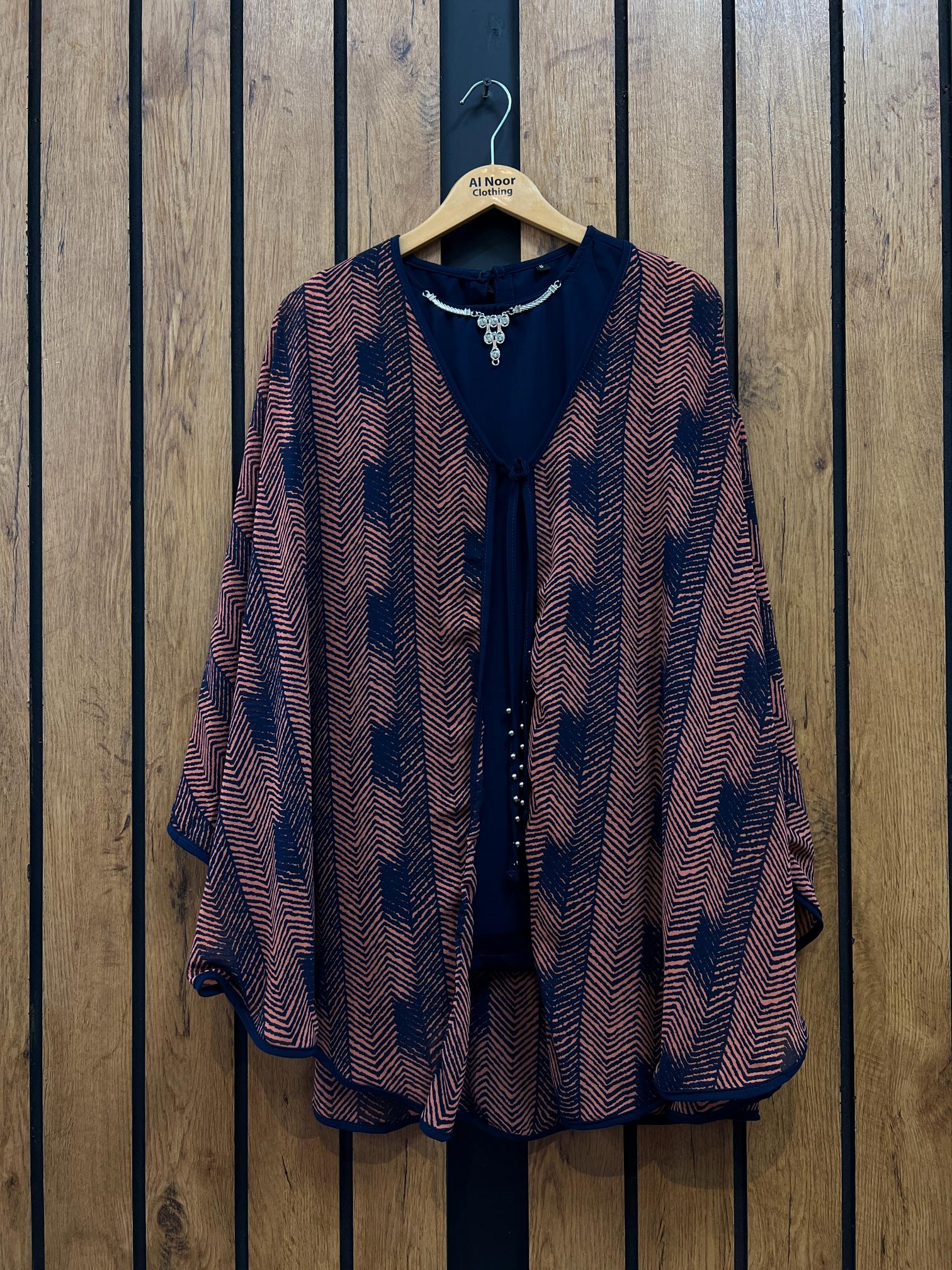 Chic women's patterned kimono-style top hanging on a wooden background