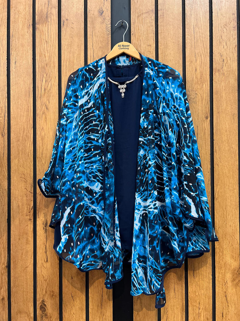 Blue and black patterned kimono-style jacket on wooden background.