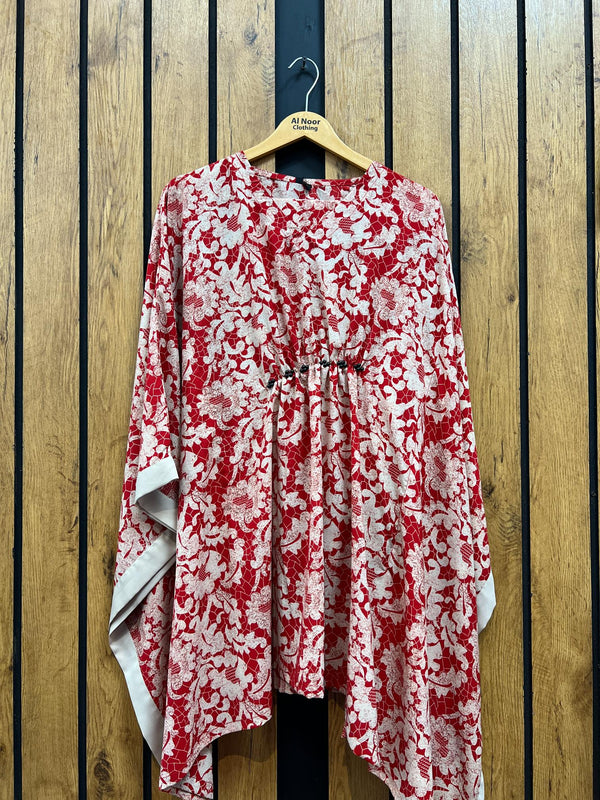 Red and white floral ladies' stitched two-piece suit hanging on wooden hanger