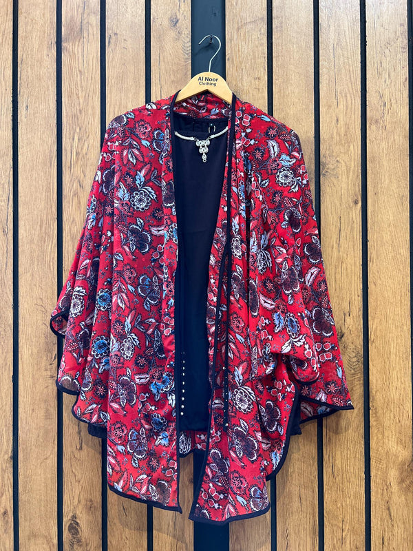 Red floral women's kimono jacket with black inner top on wooden hanger