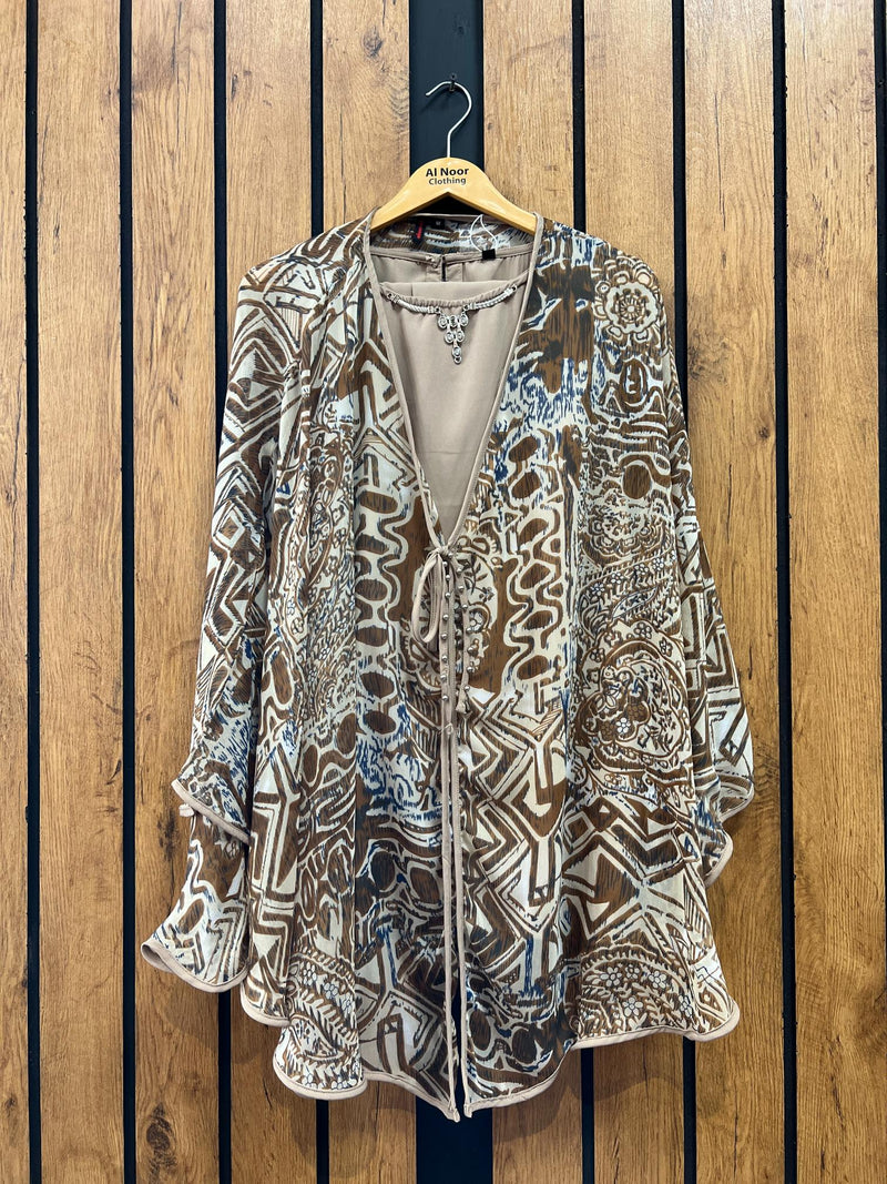 Bohemian-inspired women's kimono cardigan with intricate patterns hanging on wooden hanger against wooden backdrop.